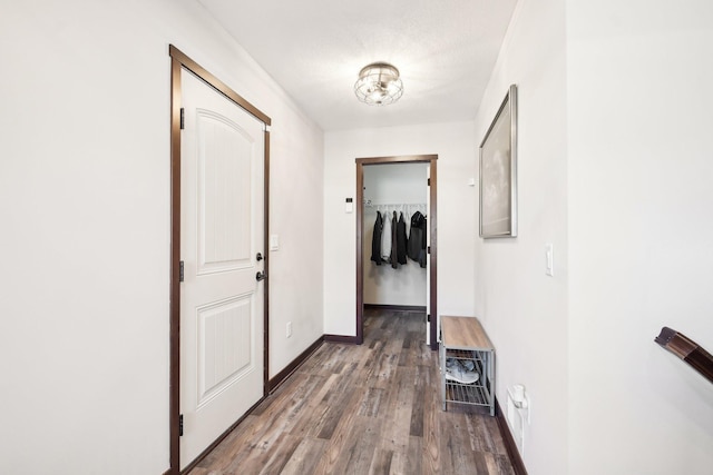 corridor with baseboards and wood finished floors