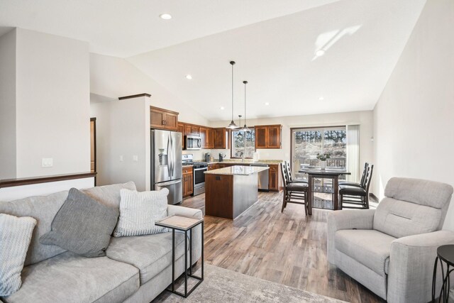 living area with lofted ceiling, light wood-type flooring, and recessed lighting