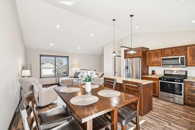 dining area with high vaulted ceiling, light wood-style flooring, and recessed lighting