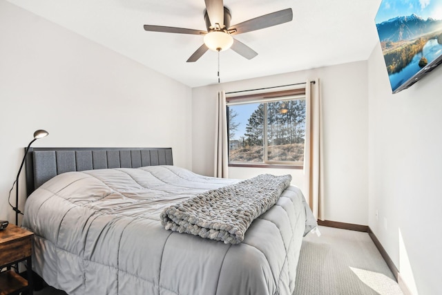 carpeted bedroom with ceiling fan and baseboards