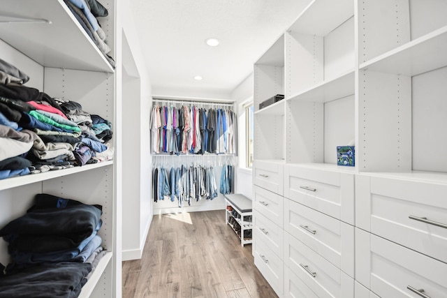 walk in closet with light wood-style flooring