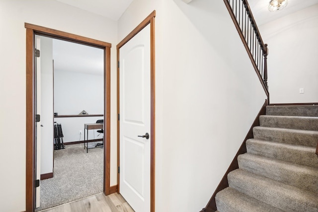 stairway with baseboards and wood finished floors