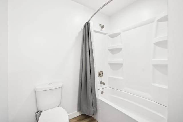 full bathroom with shower / bath combo, baseboards, toilet, and wood finished floors