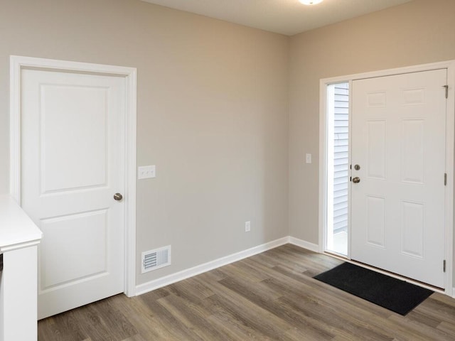 foyer with visible vents, baseboards, and wood finished floors