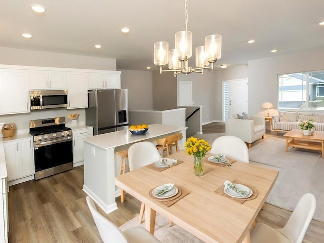 dining area with recessed lighting, a notable chandelier, and wood finished floors