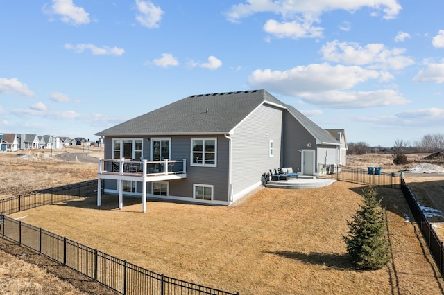 back of property with roof with shingles, a fenced backyard, a patio, and a lawn