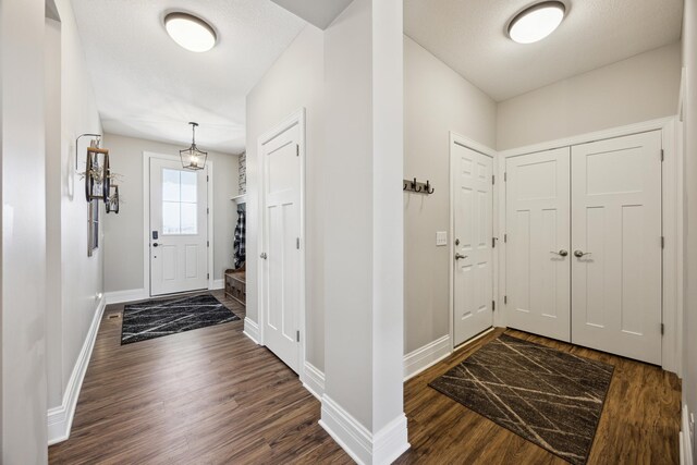 foyer with baseboards and dark wood finished floors