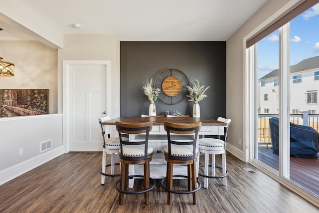 dining area with dark wood-style floors, visible vents, and baseboards