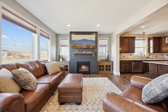 living room featuring recessed lighting, a fireplace, dark wood finished floors, and baseboards