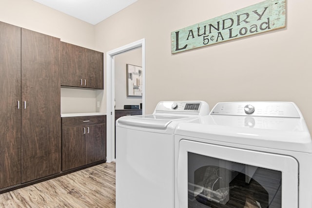 clothes washing area with laundry area, light wood finished floors, and washing machine and dryer