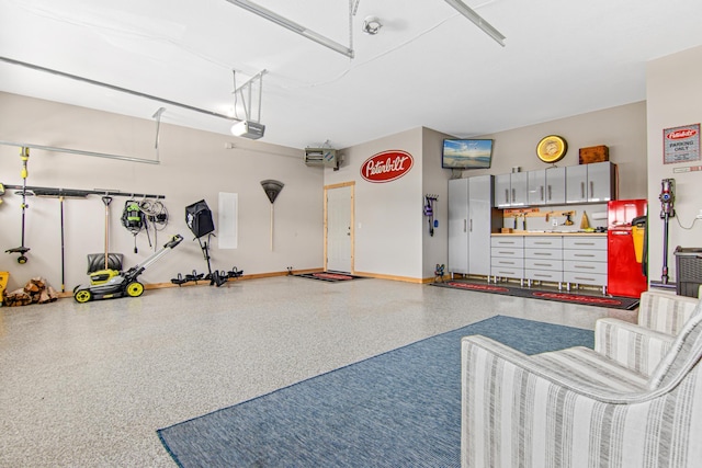 garage with baseboards and a garage door opener