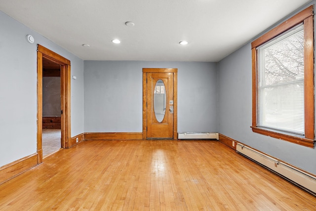 1498 Sherburne Ave, Saint Paul, MN 55104 - empty room featuring a baseboard heating unit, light wood-style floors, recessed lighting, baseboards, and a smoke detector