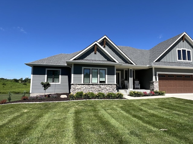 craftsman-style home featuring board and batten siding, stone siding, driveway, and a garage