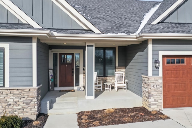 property entrance featuring stone siding, a porch, board and batten siding, and roof with shingles