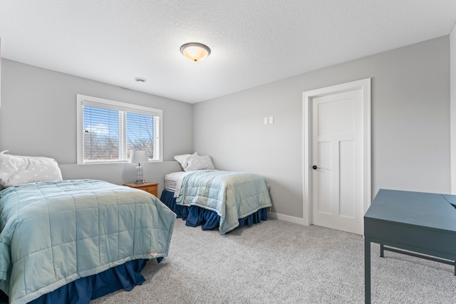 carpeted bedroom featuring a textured ceiling and baseboards