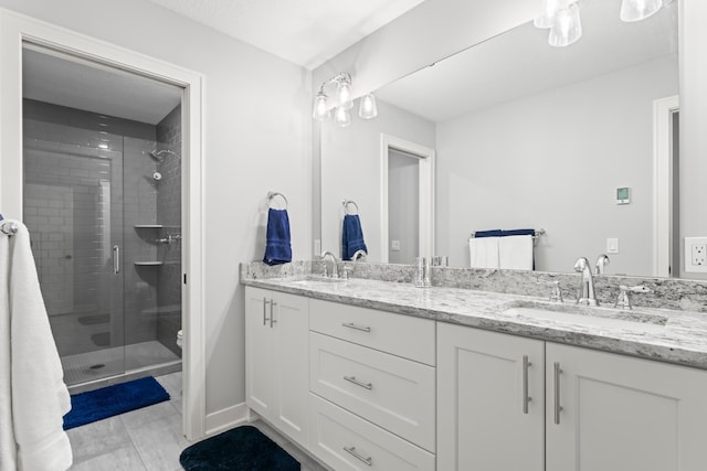 full bathroom featuring a sink, a shower stall, toilet, and double vanity