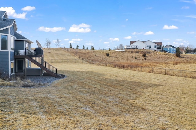 view of yard featuring fence, a deck, and stairs