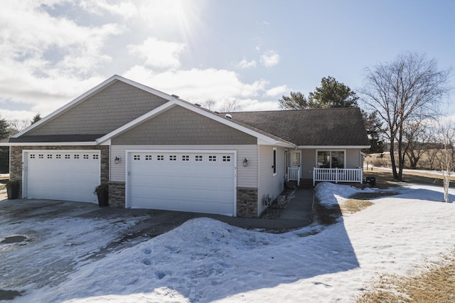 view of front of home featuring a porch, stone siding, driveway, and a garage