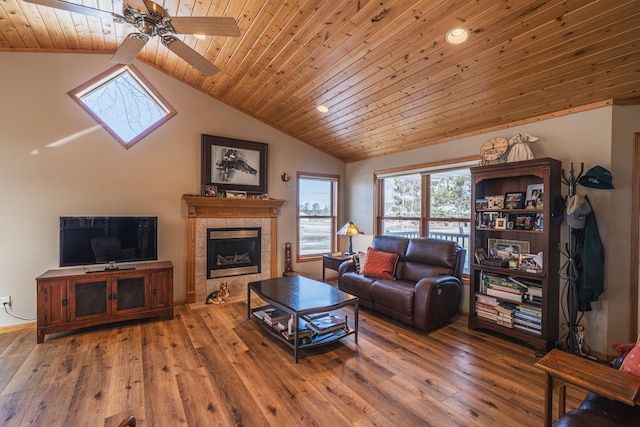 living area featuring lofted ceiling, wooden ceiling, a fireplace, a ceiling fan, and hardwood / wood-style floors