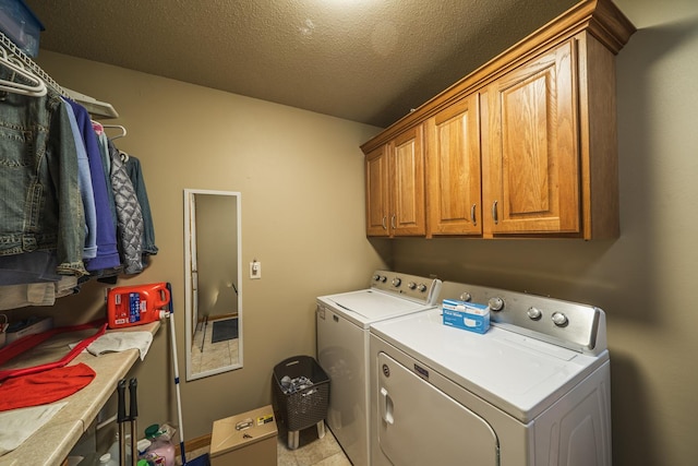 washroom with cabinet space, separate washer and dryer, and a textured ceiling