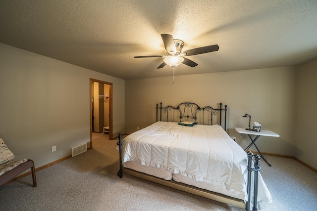 bedroom with a textured ceiling, ceiling fan, light colored carpet, visible vents, and baseboards