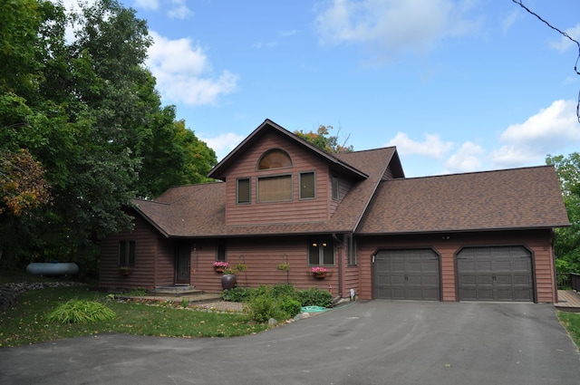 view of front of home featuring aphalt driveway, roof with shingles, and an attached garage