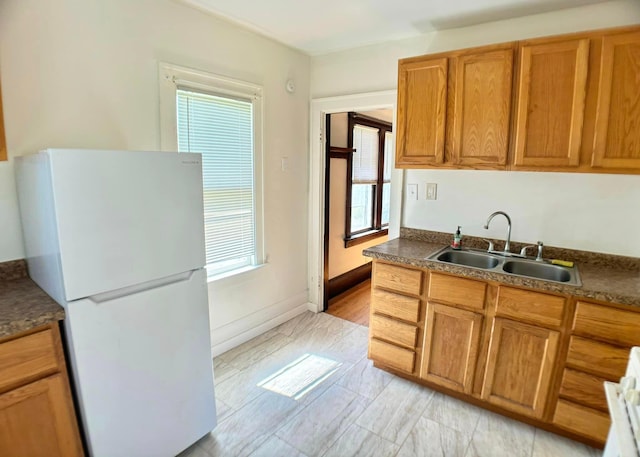 kitchen featuring white refrigerator and sink