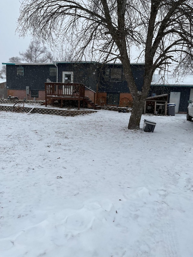 snow covered property with a deck