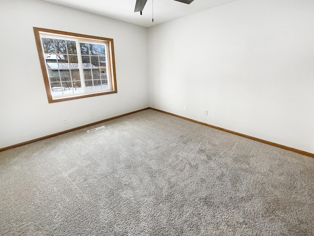 spare room with visible vents, carpet, baseboards, and ceiling fan