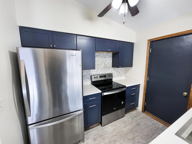 kitchen with blue cabinetry, tasteful backsplash, light countertops, lofted ceiling, and stainless steel appliances