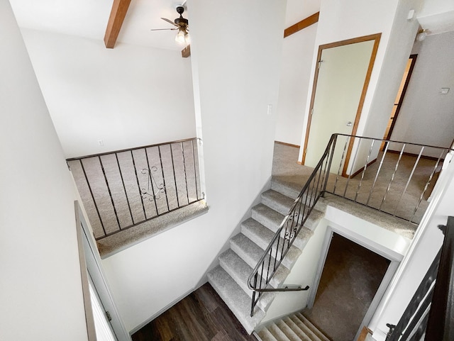stairway featuring beamed ceiling, a ceiling fan, and wood finished floors