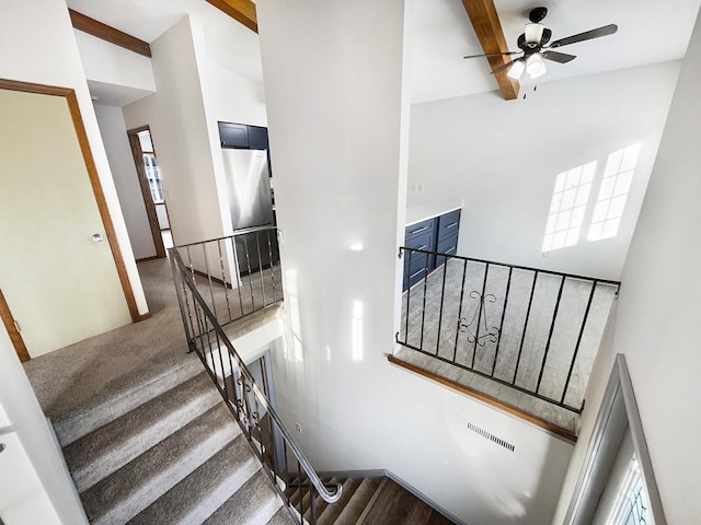 stairway featuring visible vents, ceiling fan, high vaulted ceiling, and beamed ceiling
