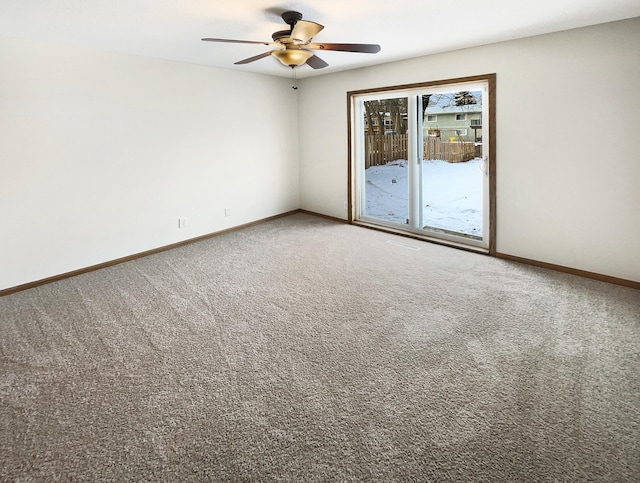 carpeted spare room with baseboards and a ceiling fan