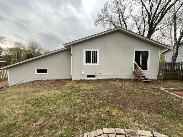 back of property with fence, crawl space, and entry steps