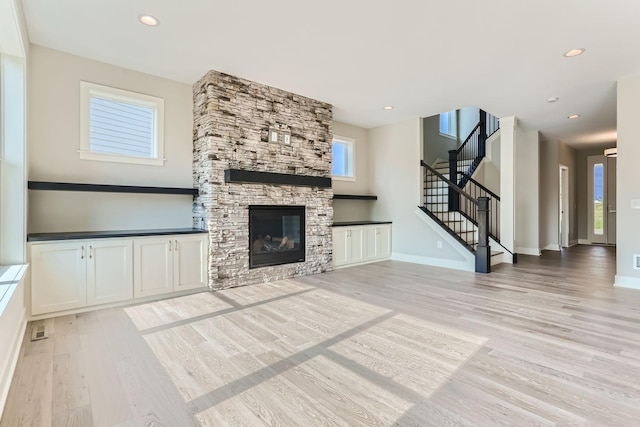 unfurnished living room with a fireplace and light wood-type flooring