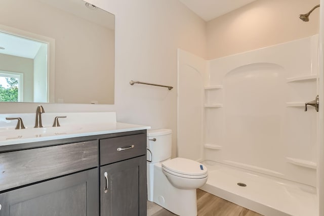 bathroom featuring vanity, hardwood / wood-style floors, toilet, and walk in shower