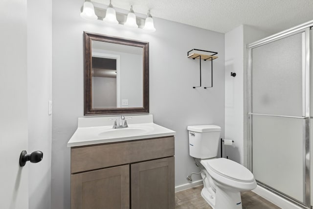 full bath with toilet, a shower stall, vanity, wood finished floors, and a textured ceiling