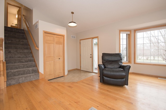 8075 211th Ave NW, Nowthen, MN 55330 - foyer entrance featuring wood finished floors, stairway, lofted ceiling, baseboards, and plenty of natural light
