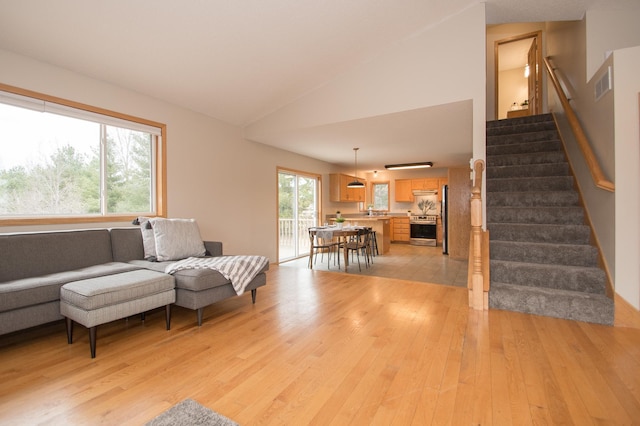 8075 211th Ave NW, Nowthen, MN 55330 - living area with light wood-style floors, stairway, and lofted ceiling