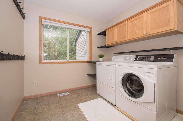 8075 211th Ave NW, Nowthen, MN 55330 - laundry area featuring washing machine and clothes dryer, cabinet space, baseboards, and light tile patterned flooring