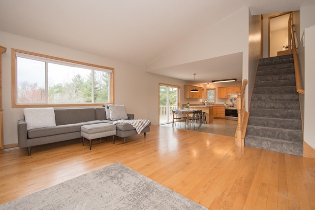 8075 211th Ave NW, Nowthen, MN 55330 - living room featuring light wood finished floors, stairway, and vaulted ceiling