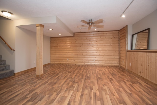 8075 211th Ave NW, Nowthen, MN 55330 - unfurnished living room with wood finished floors, wood walls, ceiling fan, stairs, and a textured ceiling