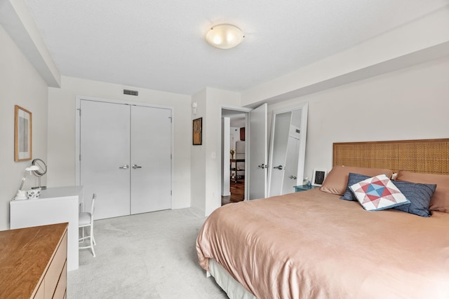 bedroom featuring visible vents, light carpet, and a closet