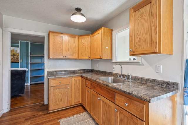 kitchen with dark hardwood / wood-style flooring, sink, and a textured ceiling