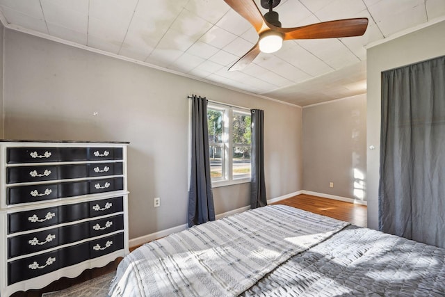 unfurnished bedroom featuring ceiling fan, ornamental molding, and wood-type flooring