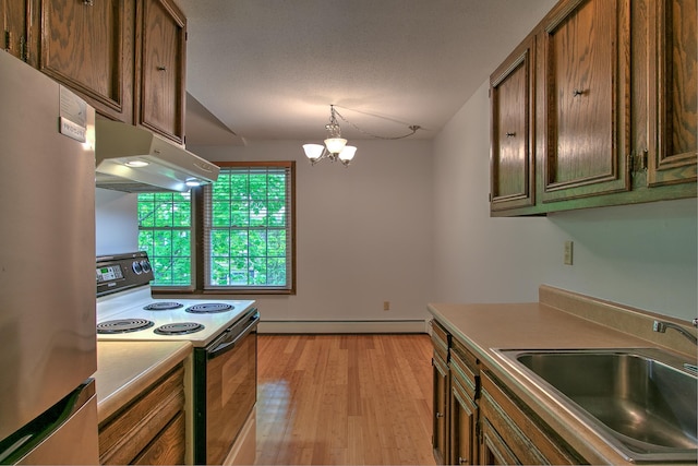 kitchen with range with electric cooktop, freestanding refrigerator, under cabinet range hood, a baseboard heating unit, and a sink