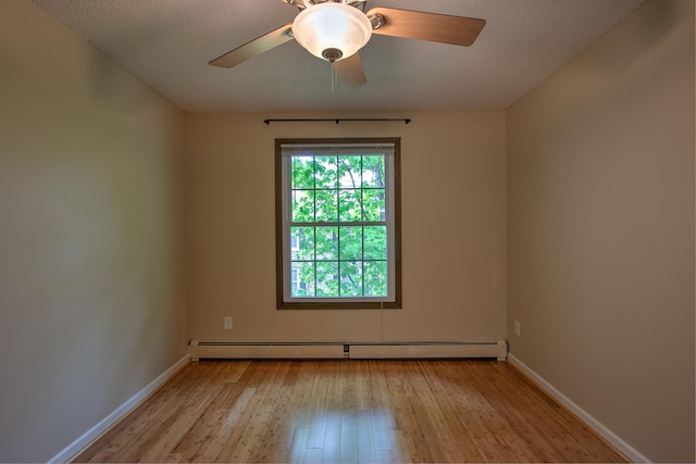 unfurnished room with light wood finished floors, baseboards, a ceiling fan, a textured ceiling, and a baseboard heating unit