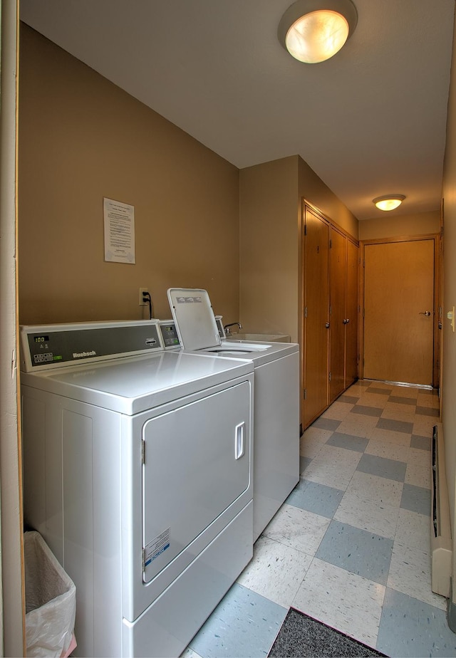 common laundry area with light floors and washing machine and clothes dryer