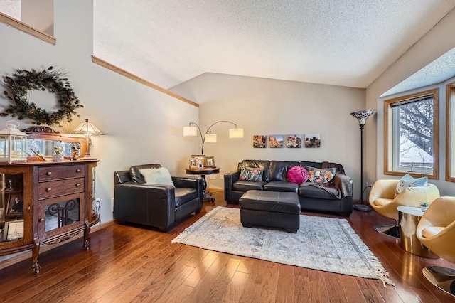 living area featuring vaulted ceiling, hardwood / wood-style floors, and a textured ceiling