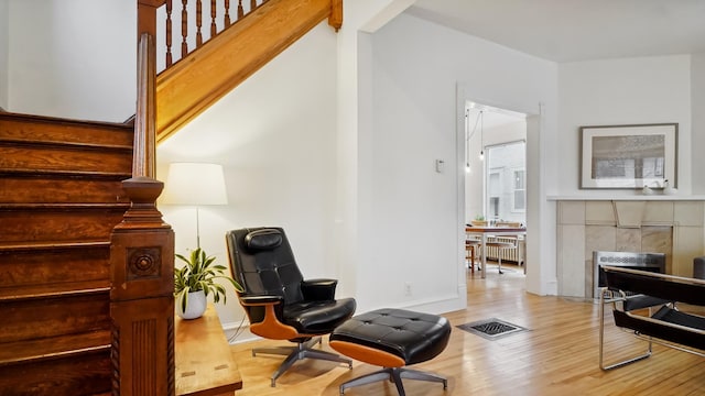 living area featuring stairway, visible vents, wood finished floors, and a fireplace